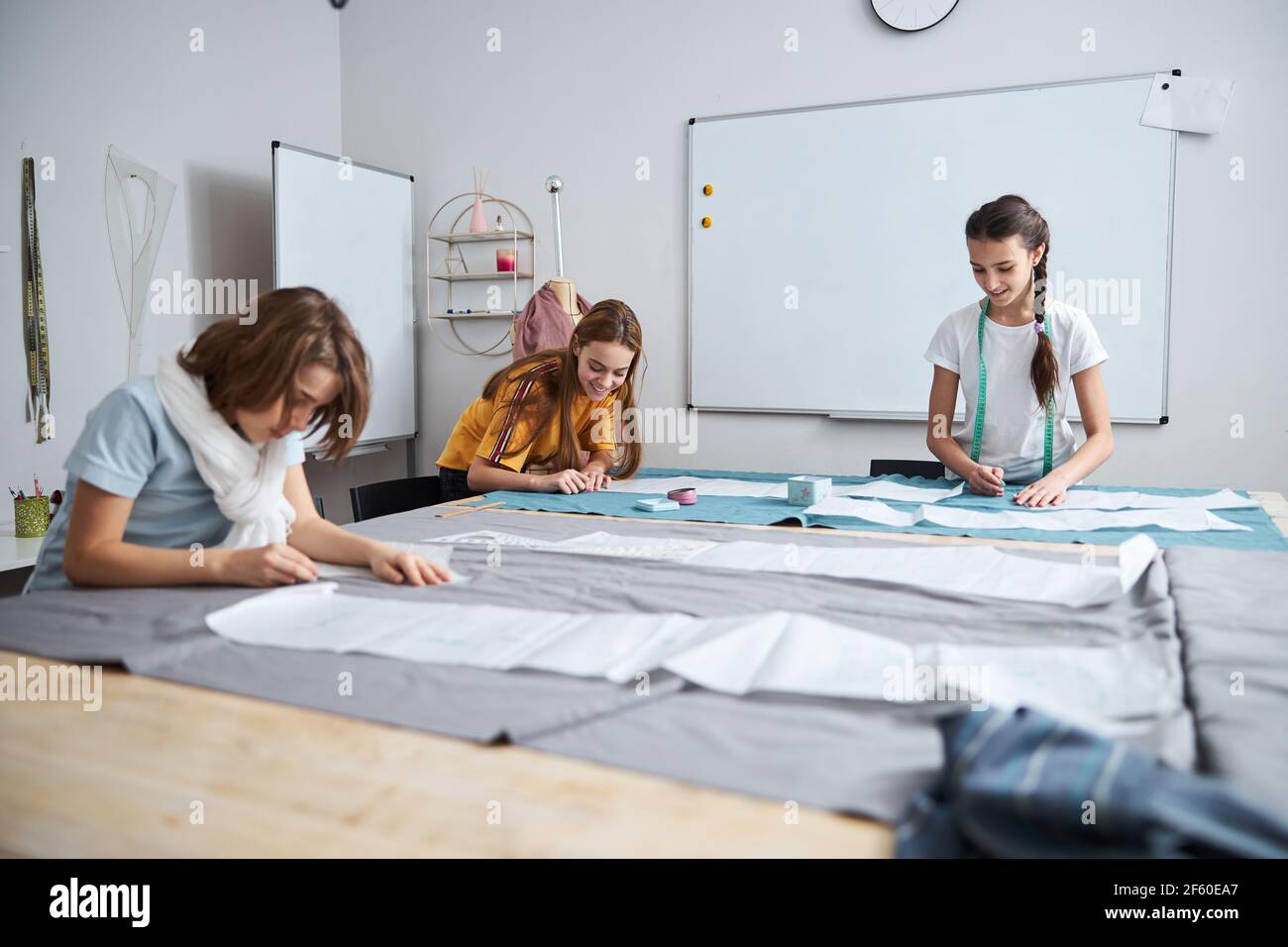 Joyful female kids working in sewing workshop Stock Photo