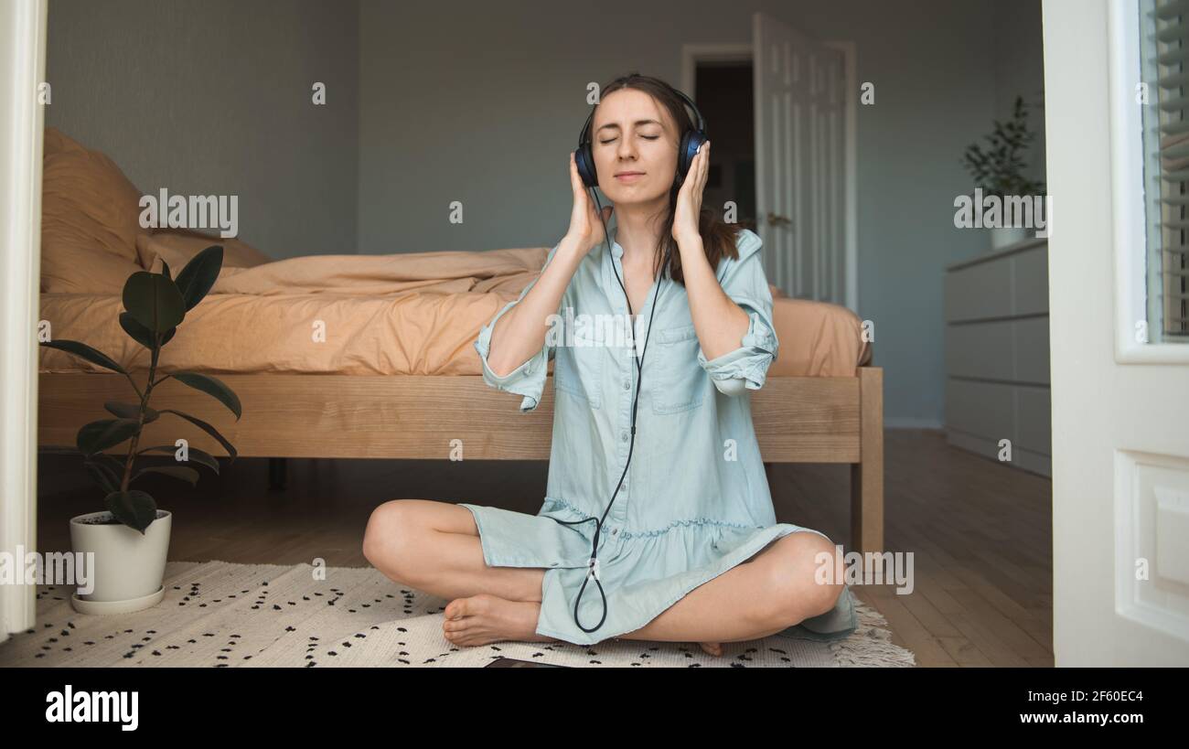 Woman on the floor listening to music with closed eyes Stock Photo - Alamy