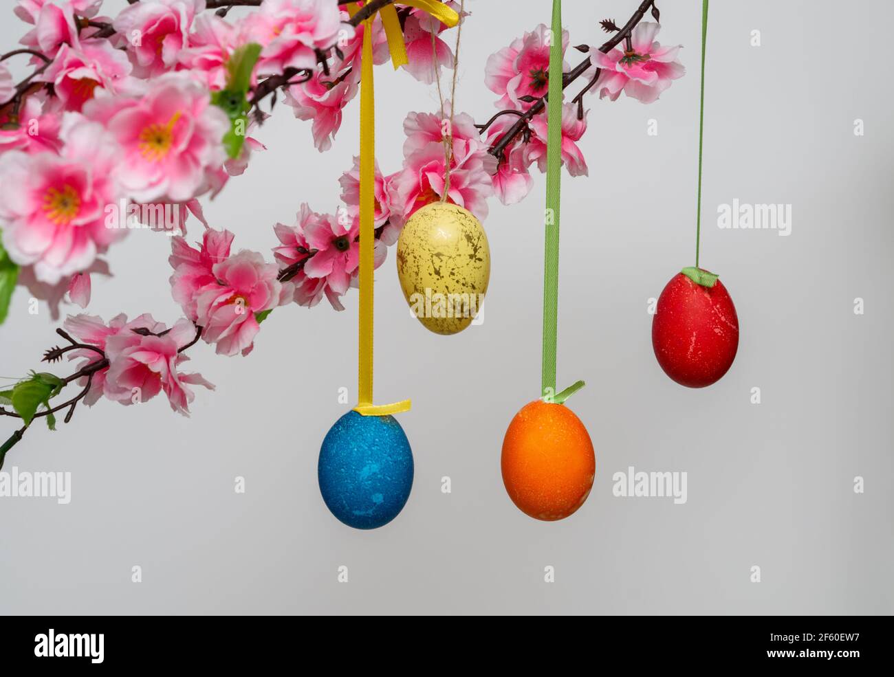 Easter background composition with hanging eggs on a branch, on a white background Stock Photo