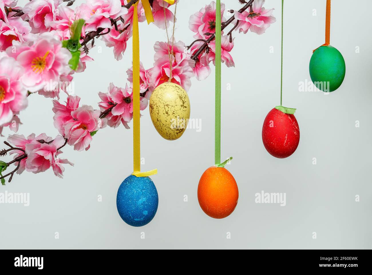 Easter background composition with hanging eggs on a branch, on a white background Stock Photo