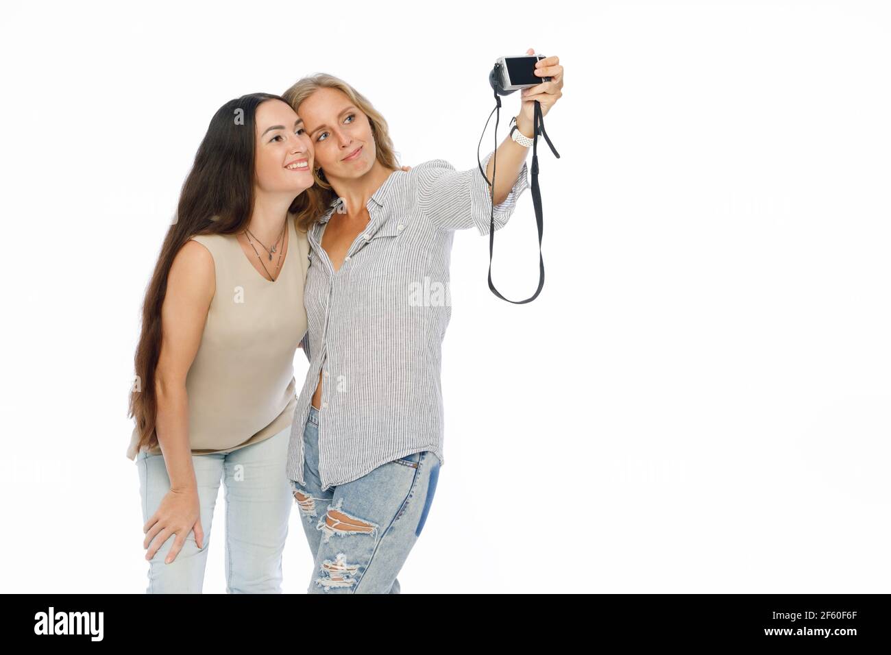 Positive friends portrait of two happy young women making selfie, sure funny faces, joy, emotions, casual style, pastel colors. Lifestyle concept. Stock Photo