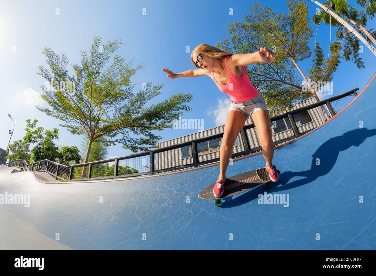 Skateboarder in action. Young woman making trick on surf skate longboard in  outdoor skatepark bowl. Surfskate and skateboard riding lessons at summer  Stock Photo - Alamy