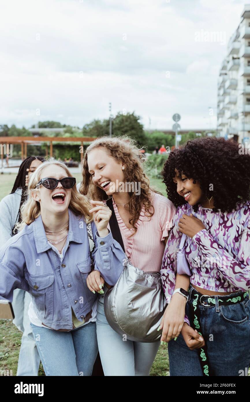 Cheerful female friends walking in park Stock Photo