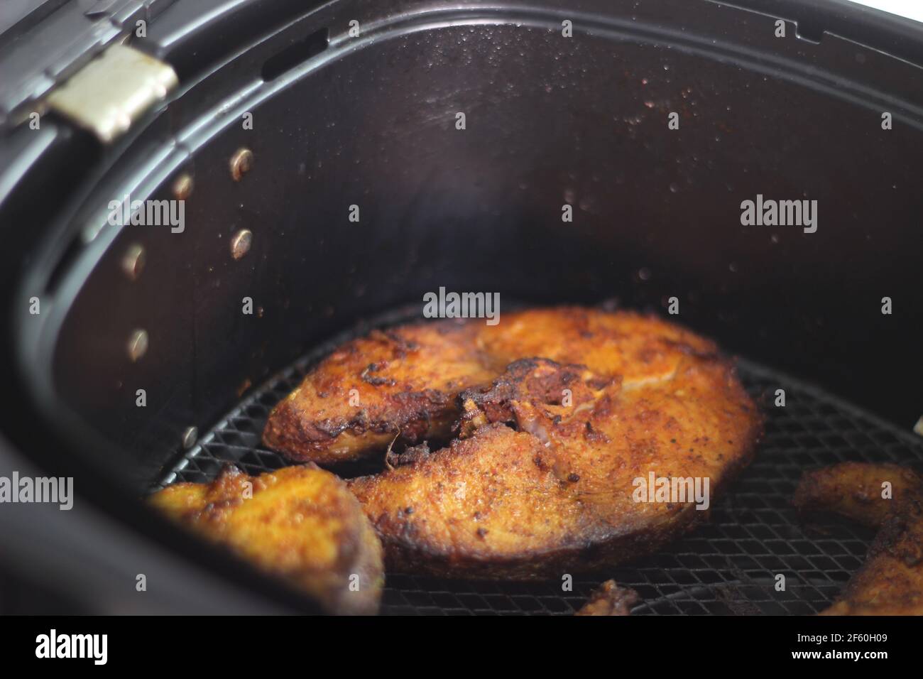 Cobia fish inside the air fryer. In India it is called Moda fish. Other common names include black kingfish, black salmon, ling, lemonfish, crabeater, Stock Photo