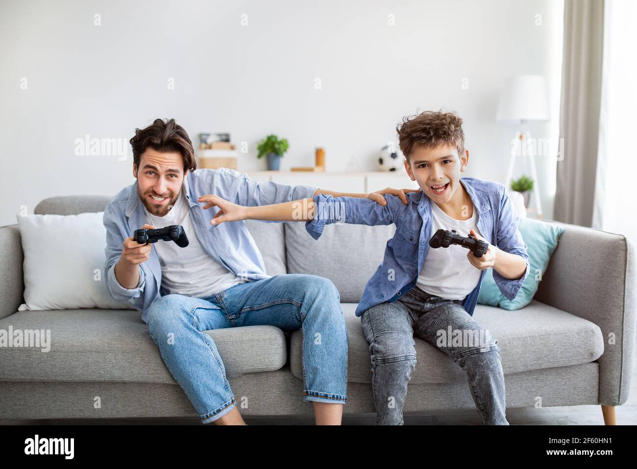 Leisure activities concept. Joyful father and son competing in playing