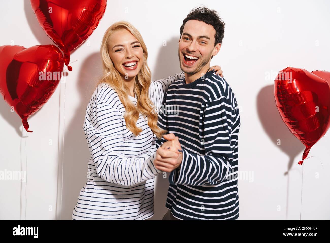 Happy attractive young couple celebrating Valentines Day with red heart ...