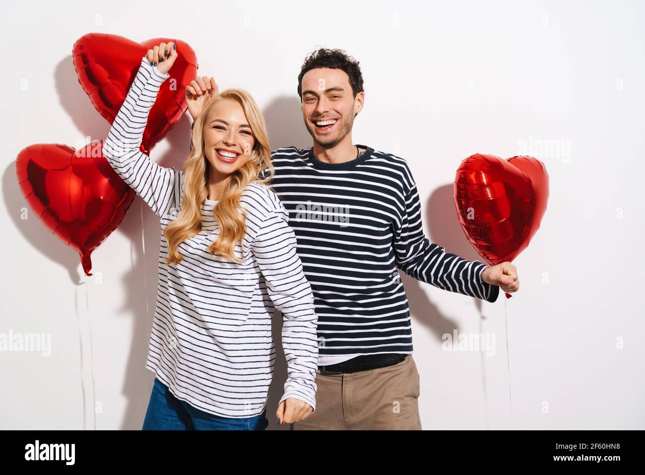 Happy attractive young couple celebrating Valentines Day with red heart ...