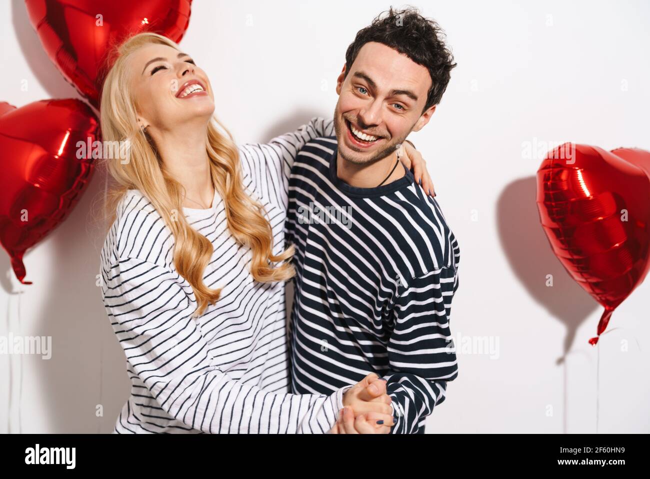 Happy attractive young couple celebrating Valentines Day with red heart ...