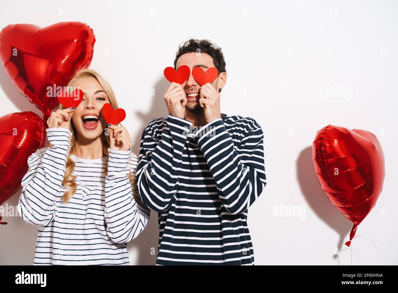 Happy attractive young couple celebrating Valentines Day with red heart ...