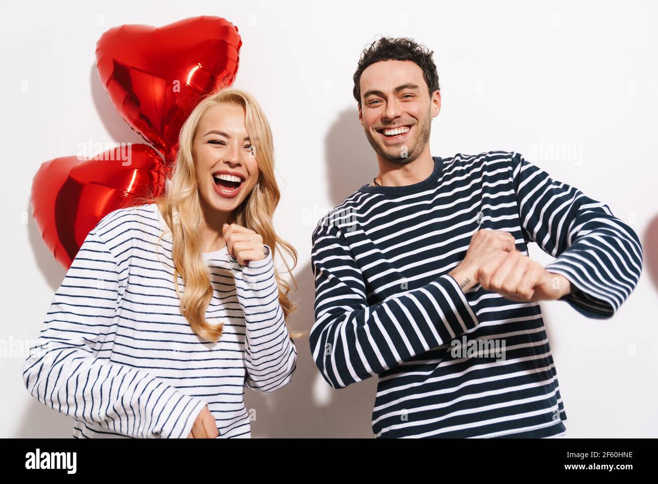 Happy attractive young couple celebrating Valentines Day with red heart ...