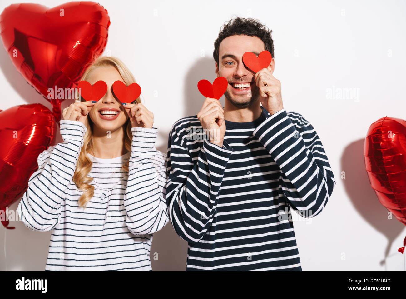 Happy attractive young couple celebrating Valentines Day with red heart ...