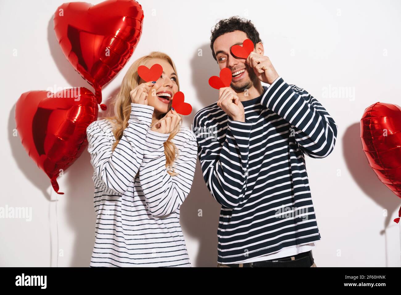 Happy attractive young couple celebrating Valentines Day with red heart ...