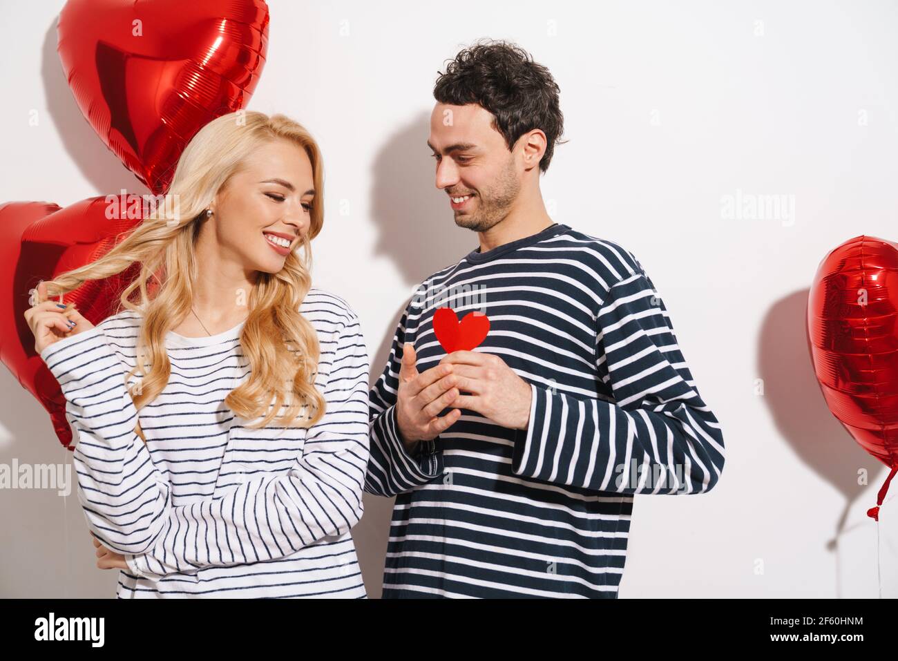 Happy attractive young couple celebrating Valentines Day with red heart ...