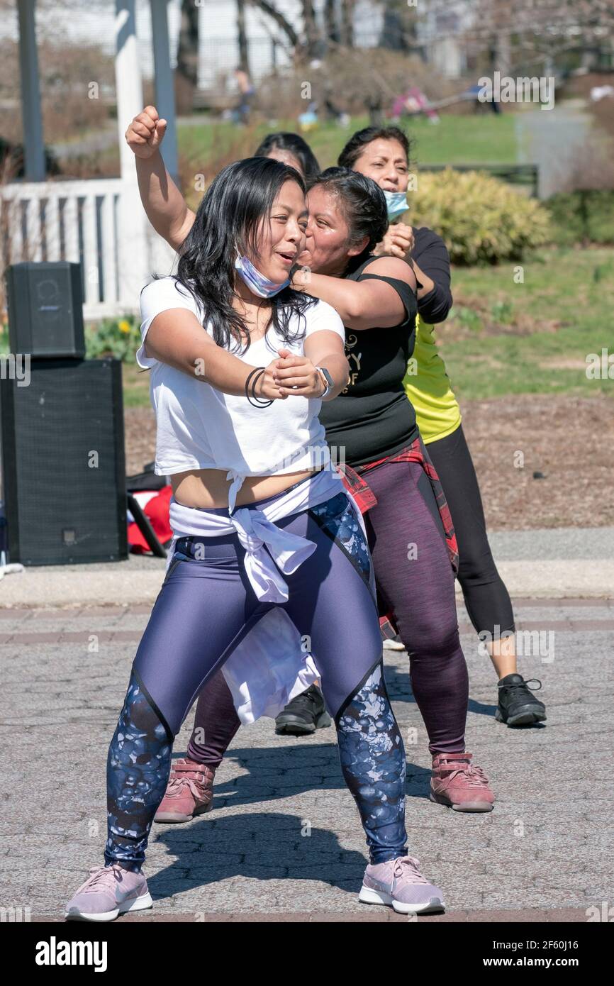 4 women of various ethnicities enjoy a moment at a Zumba class in Flushing Meadows Corona Park in Queens, New York City Stock Photo