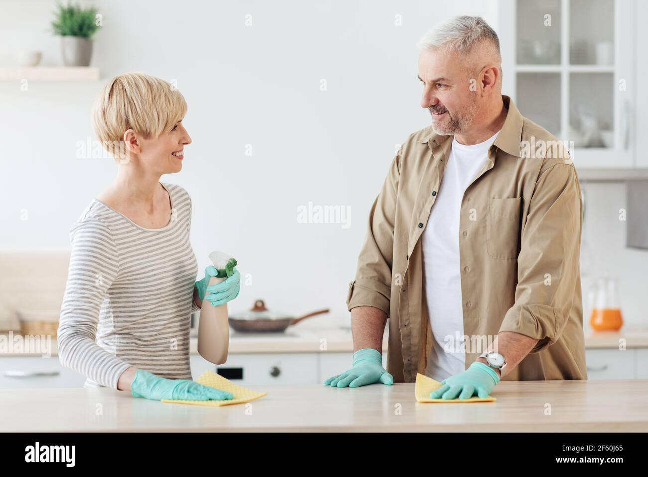 Happy couple enjoying cleaning house together, home hygiene, relationships and domestic life Stock Photo
