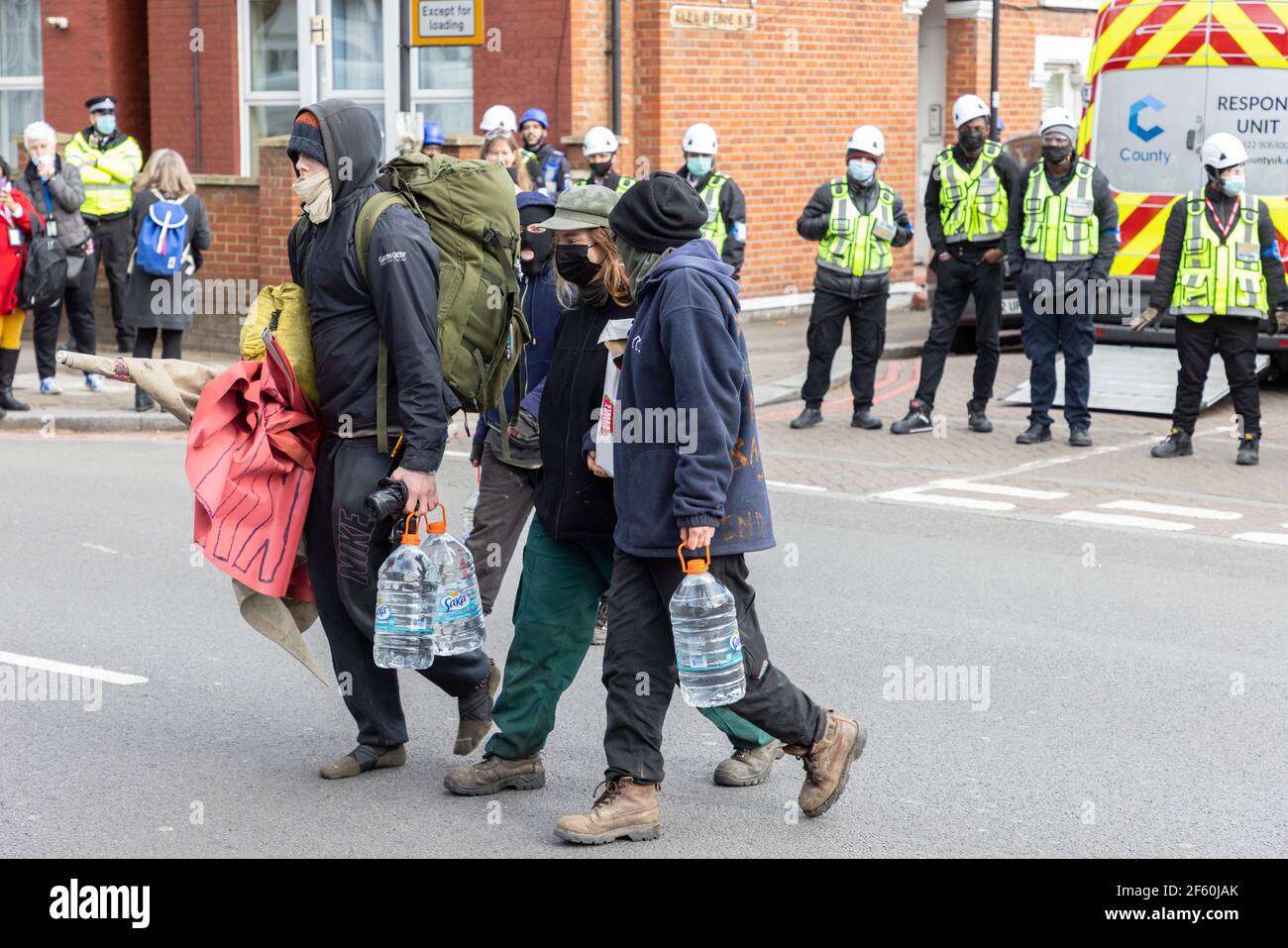 London, United Kingdom. 29th Mar, 2021. Evicted protesters leave the premises. The police station had been occupied by squatters and autonomous activists under the name of ‘Not A Cop Shop’ for over a week, in opposition to the new ‘Police, Crime, Sentencing, and Courts Bill’ and femicide. Cavendish Road Police Station, Clapham, London, United Kingdom. Credit: Joshua Windsor/Alamy Live News. Stock Photo