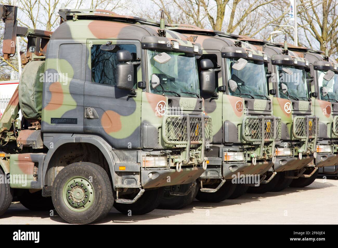 Arnhem, Netherlands - March 6, 2021: Dutch military Scania trucks painted in camouflage colors on a row on a parking lot Stock Photo