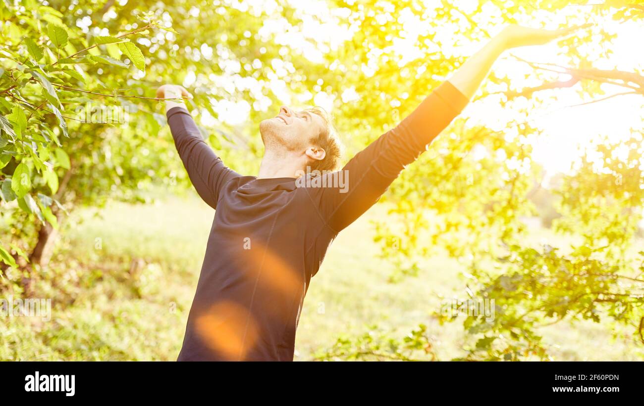 Happy man in nature does breathing exercise for air in summer Stock Photo