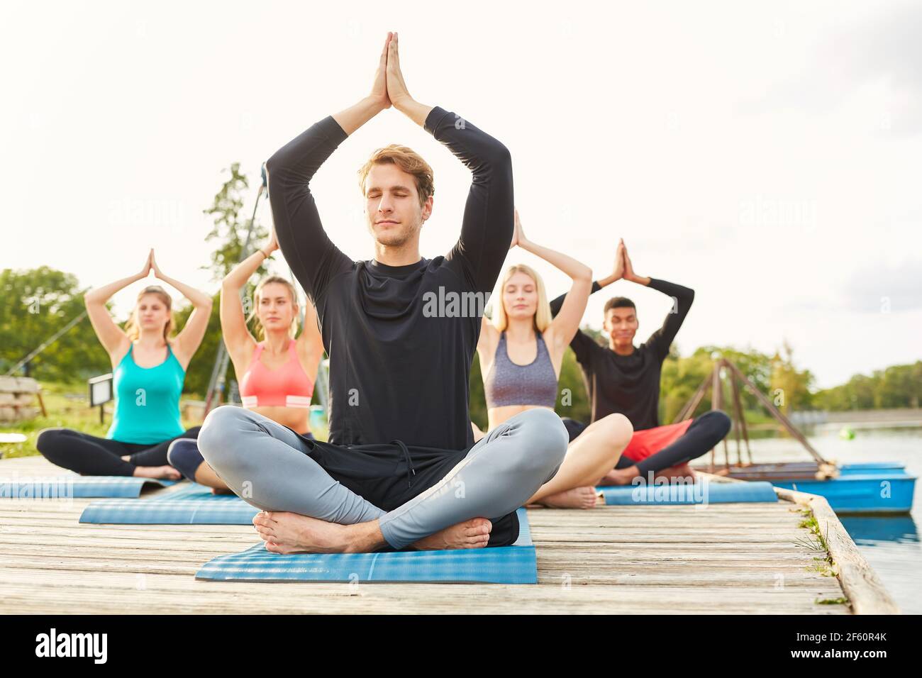 Group of people doing a yoga meditation in nature for relaxation and enlightenment Stock Photo