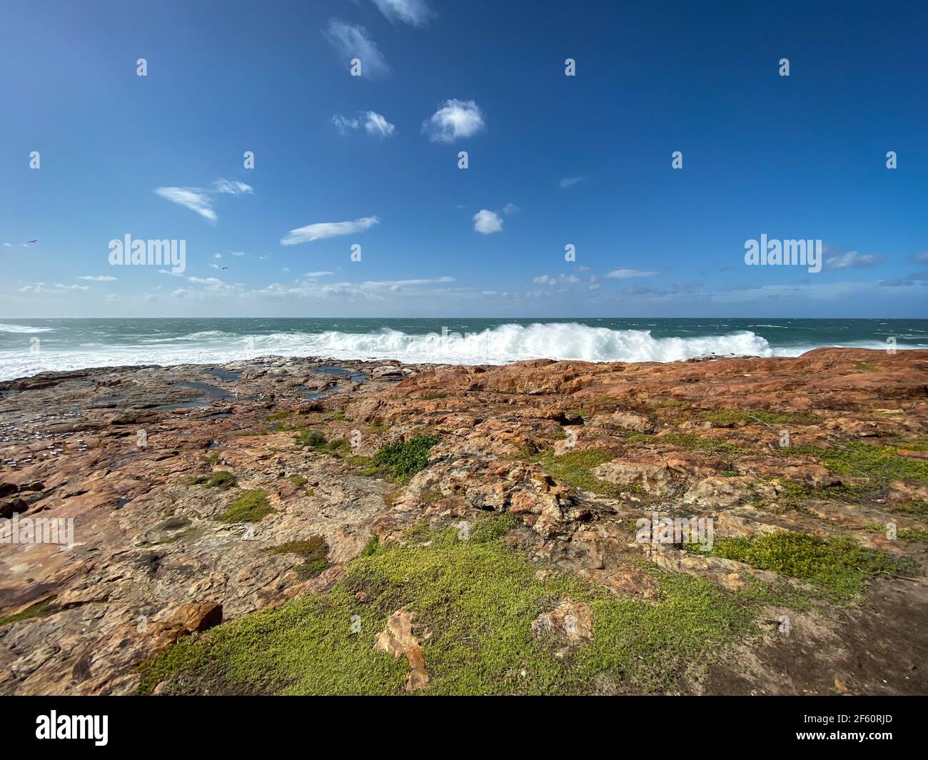 Scenic view of waves crashing against rocks at “The Point” along Robberg Nature Reserve hiking trail, Plettenberg Bay, South Africa Stock Photo