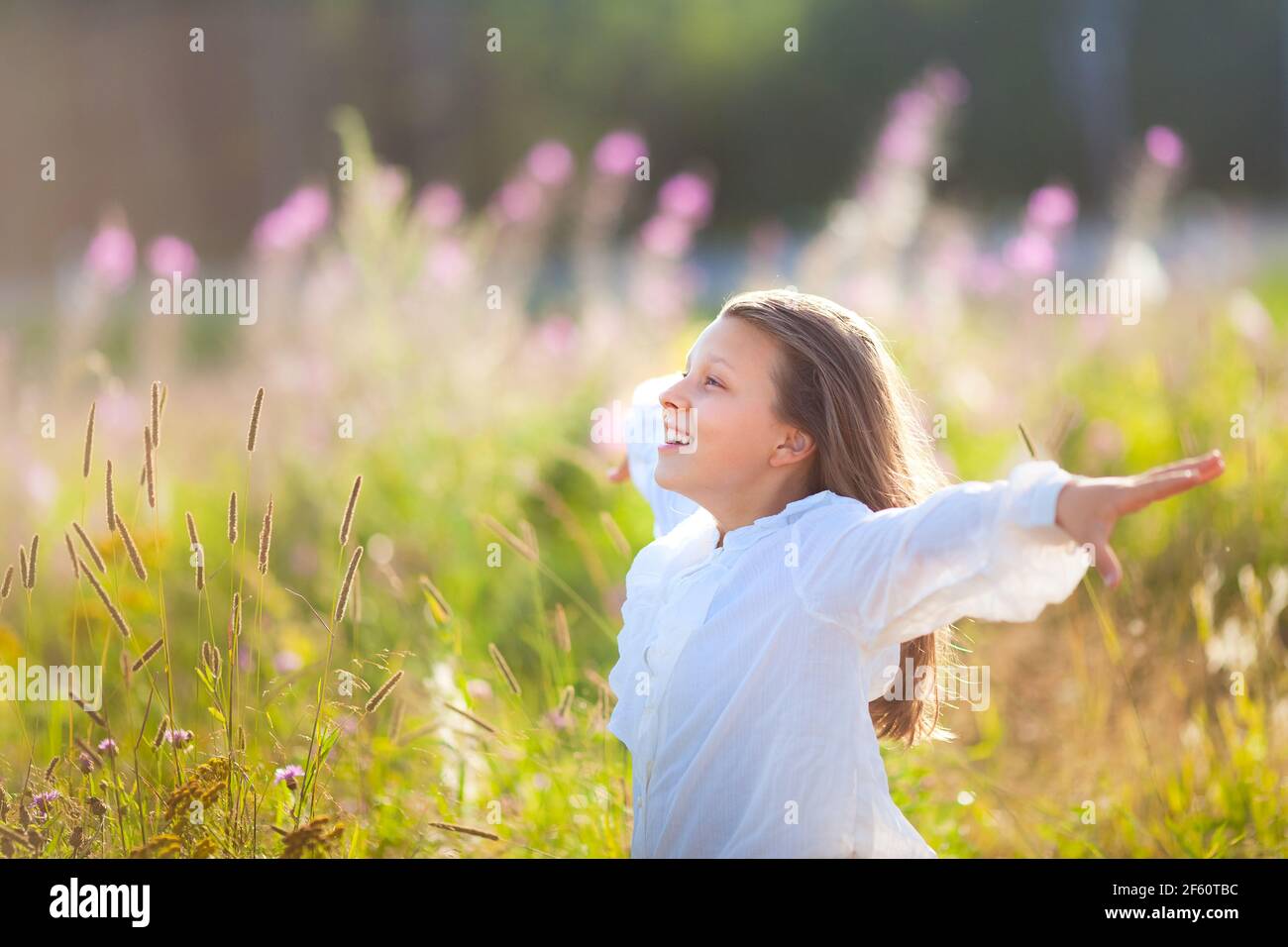 Smiling 13 Year Old Girl Stands Confidently at Sunset on Trail Stock Photo