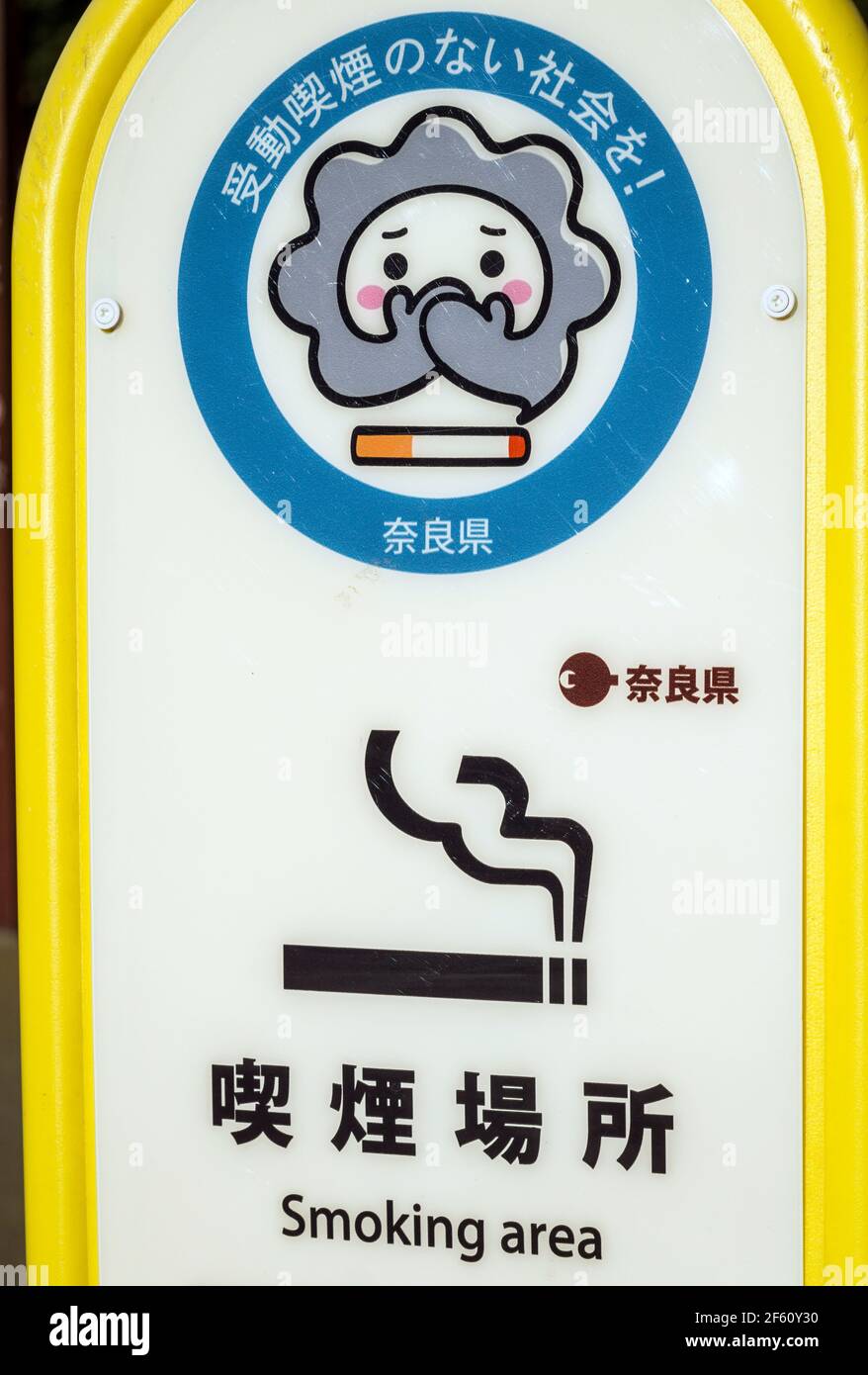 A sign with a cartoon character designating a Smoking Area in Nara, Japan. Sign reads 'Let's create a society without passive smoking' Stock Photo