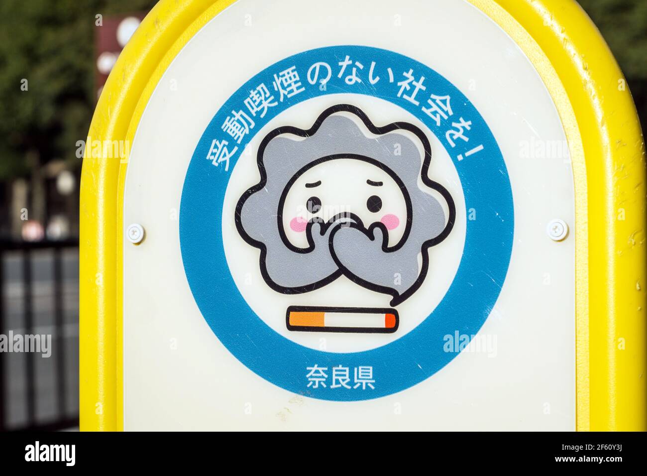 A sign with a cartoon character designating a Smoking Area in Nara, Japan. Sign reads 'Let's create a society without passive smoking' Stock Photo
