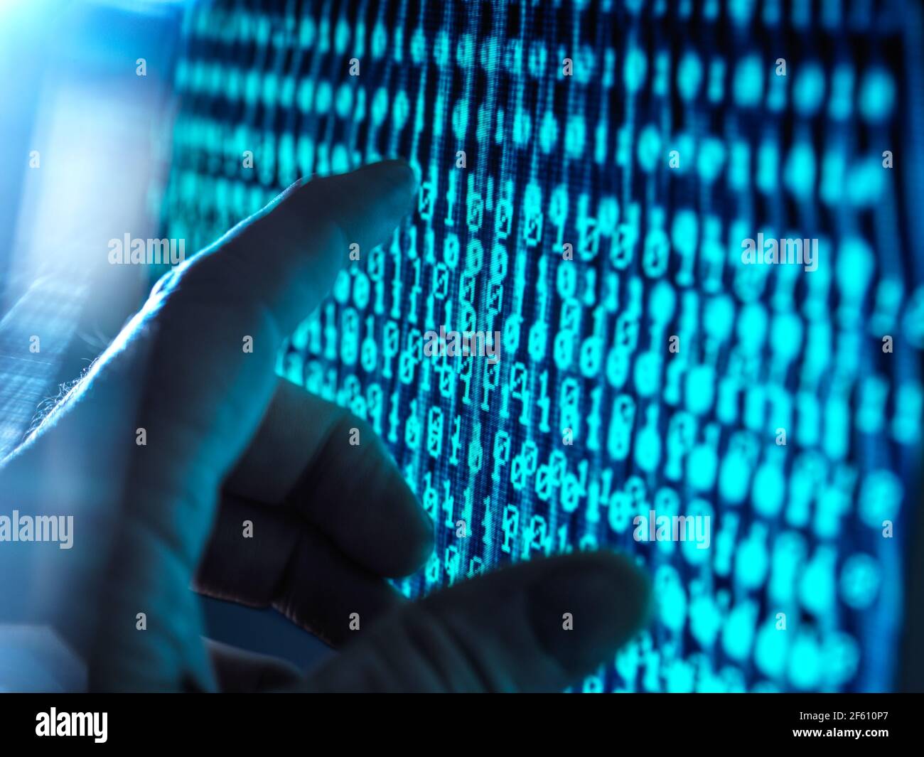 Network Security, Hand about to touch a computer screen with data streaming through Stock Photo