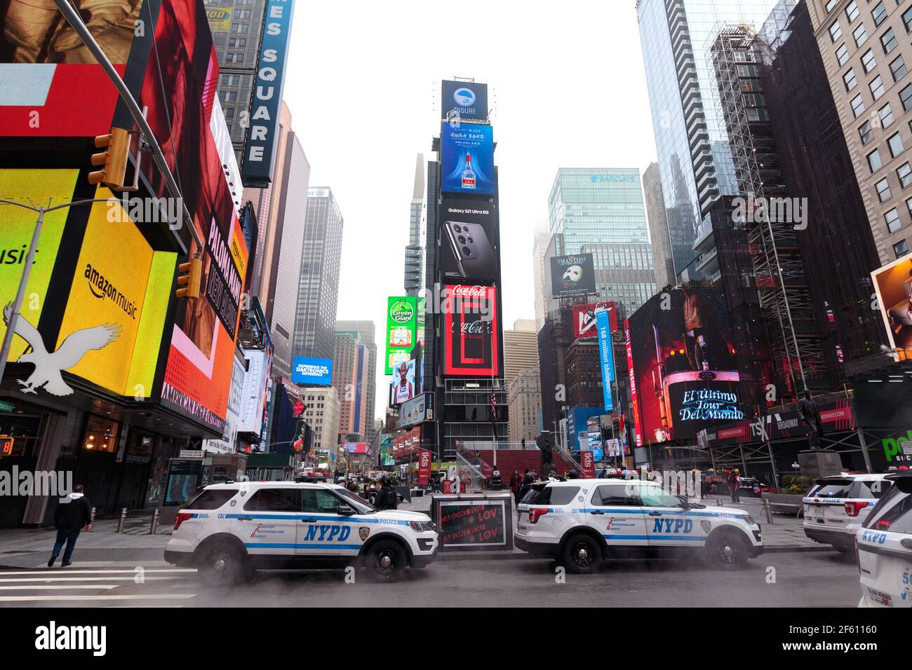 NYPD cars parked in Times Square on a foggy day, the famous Coca Cola digital billboard is seen in the background Stock Photo