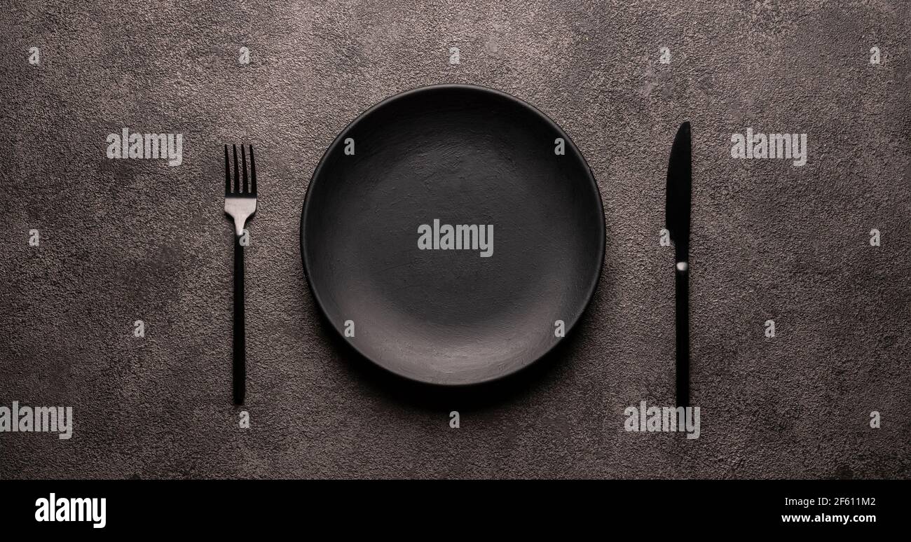 black empty plate and cutlery, fork and knife, on a dark textured background.  Mockup concept for the design of a restaurant menu, website or design. l  Stock Photo - Alamy