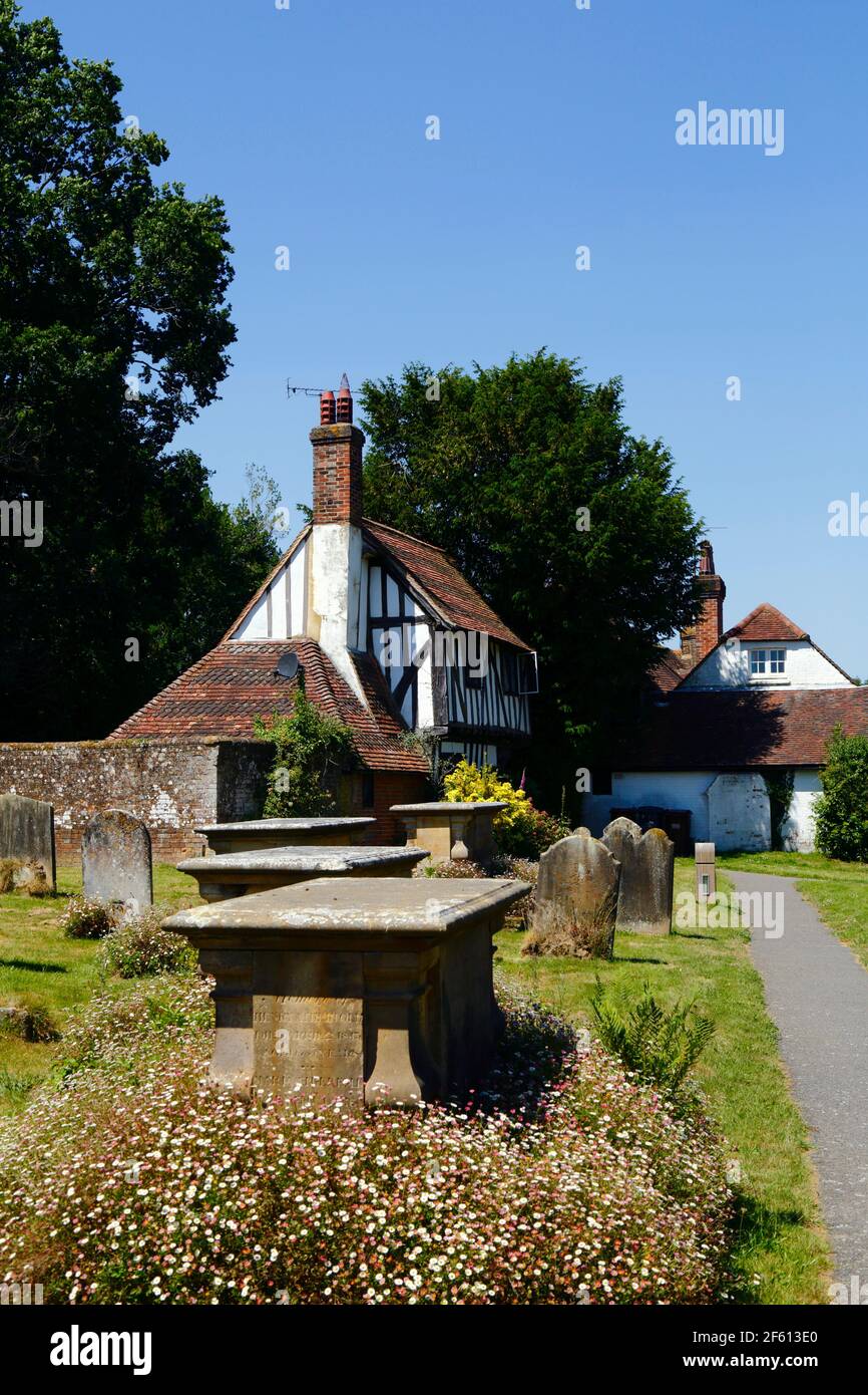 Chest tomb of Elliott family and historic timber framed cottage at entrance to St Mary the Virgin churchyard, Hartfield, East Sussex, England Stock Photo