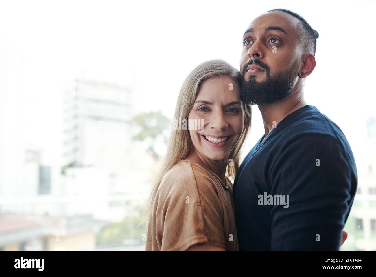 Cheerful mixed-race couple in love hugging when standing outdoors Stock Photo