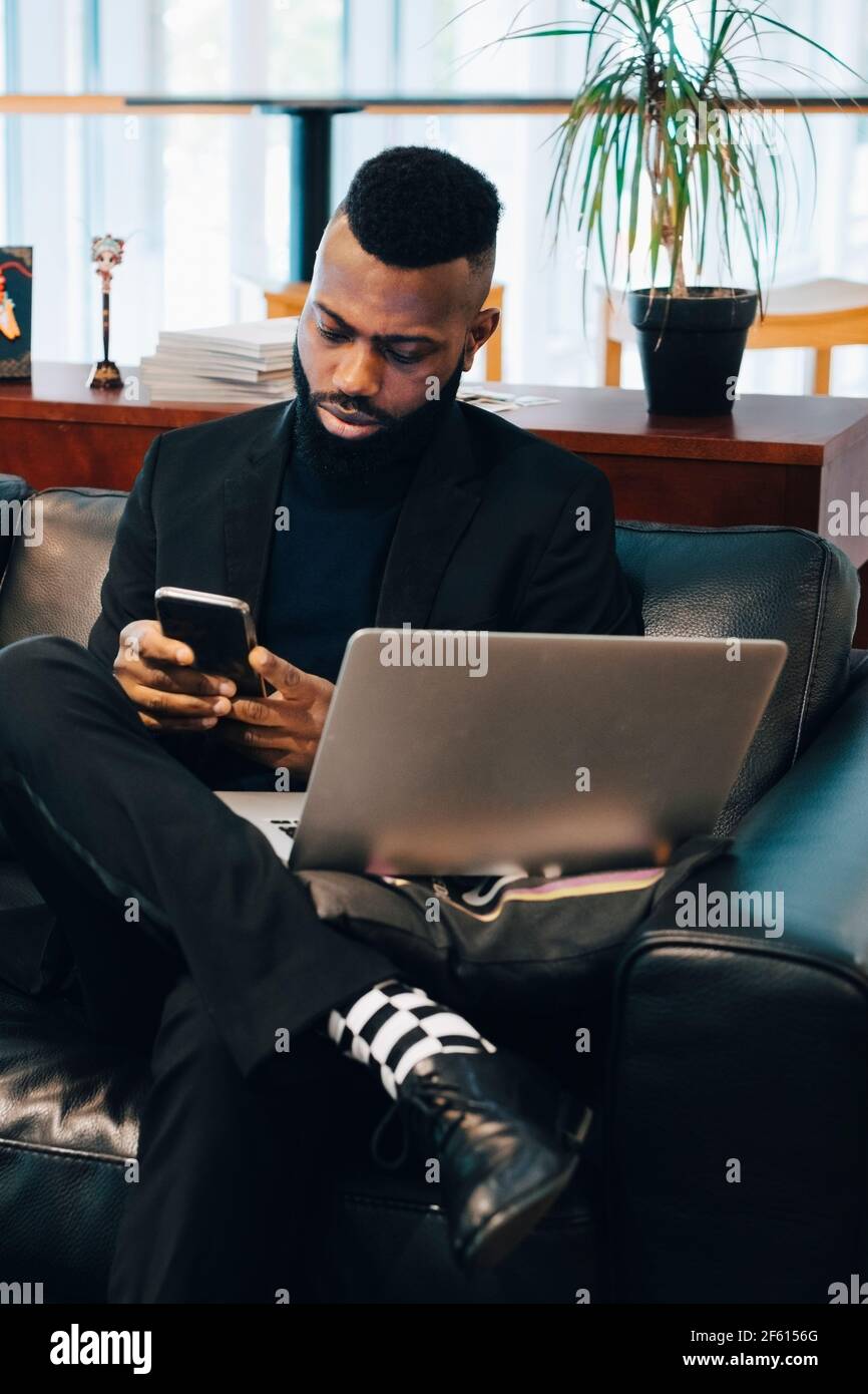 Businessman using smart phone while working in office Stock Photo