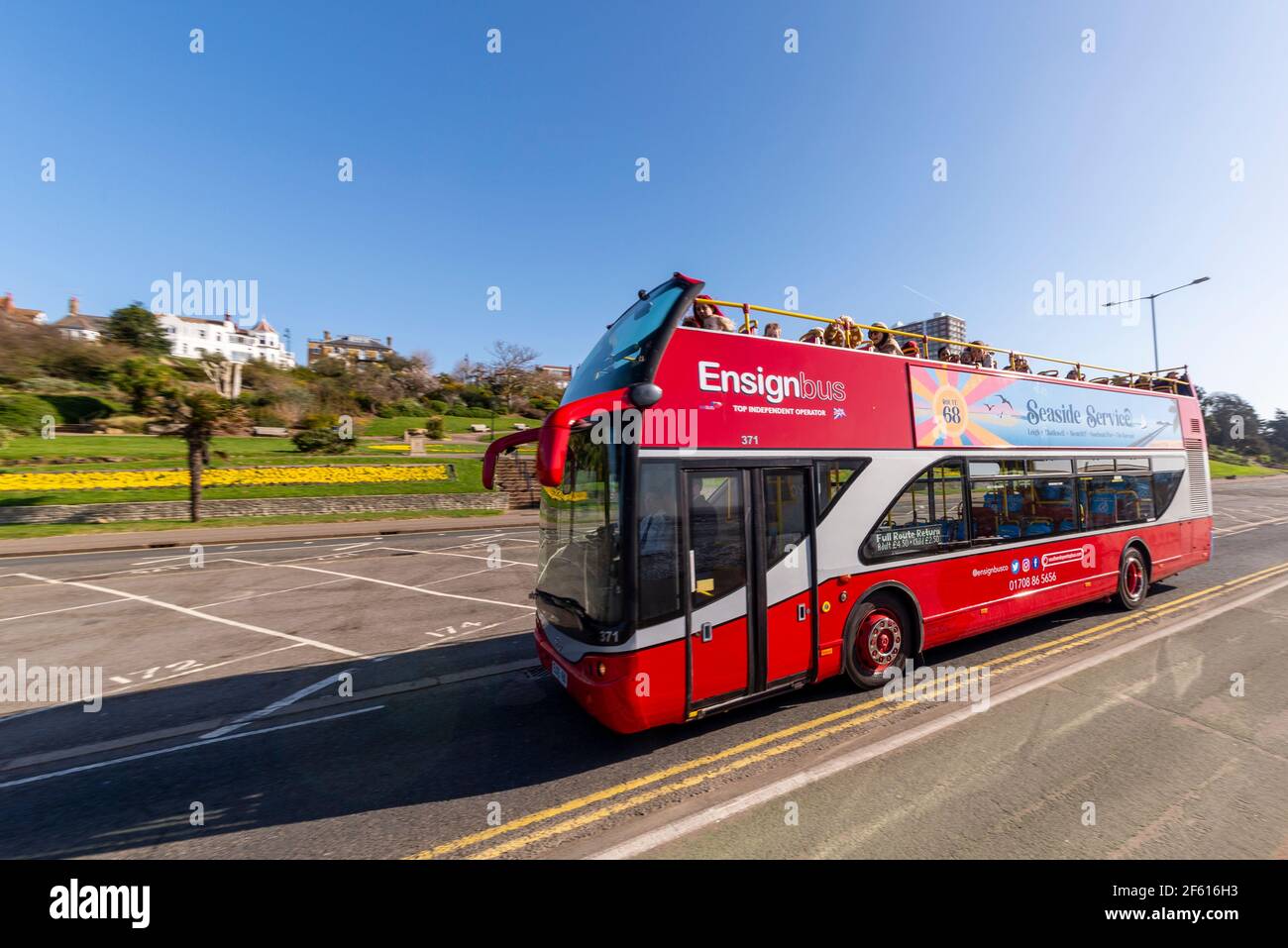 EnsignBus open top bus service in Southend on Sea, Essex, UK. Seaside Service Route 68, passing bright colourful Cliff Gardens on sunny day Stock Photo