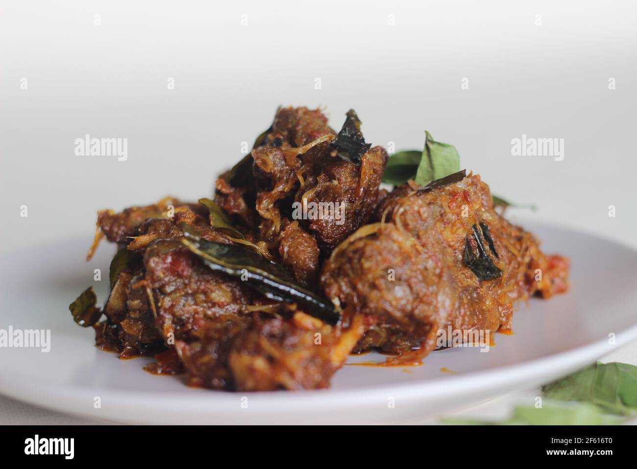 Kerala style mutton roast prepared with coconut oil. Shot on white background Stock Photo