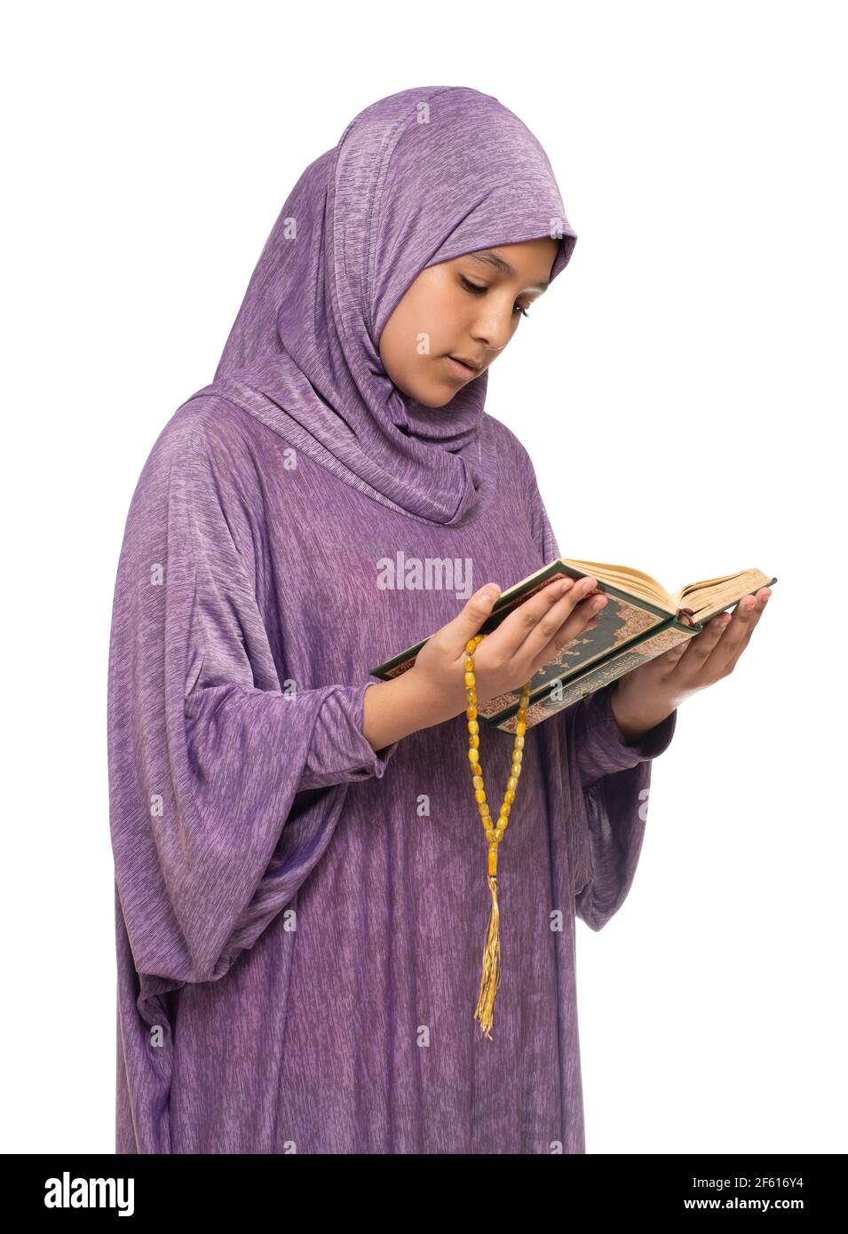 Beautiful Arab Muslim Girl in Islamic Fashion Dress Reading Holy Book of Quran With Happy Smily Face, Isolated on White Background Stock Photo