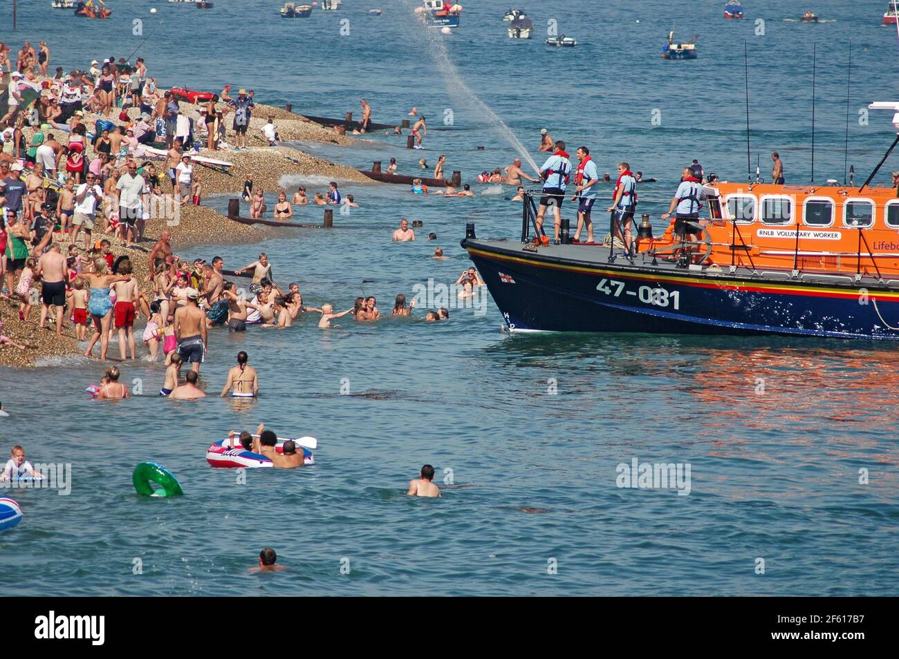 RNLI all weather Tyne Class Lifeboat 'Voluntary Worker' spraying the spectators with water in the finale of Lifeboat Launch Day, Selsey, West Sussex, Stock Photo