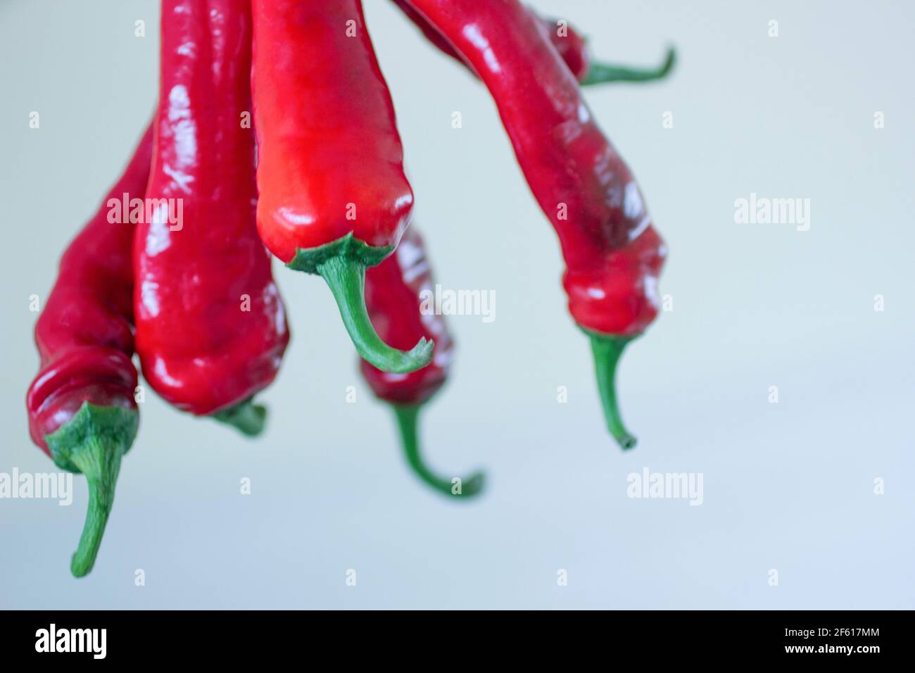Group of red hot chili peppers hanging upside down Stock Photo - Alamy