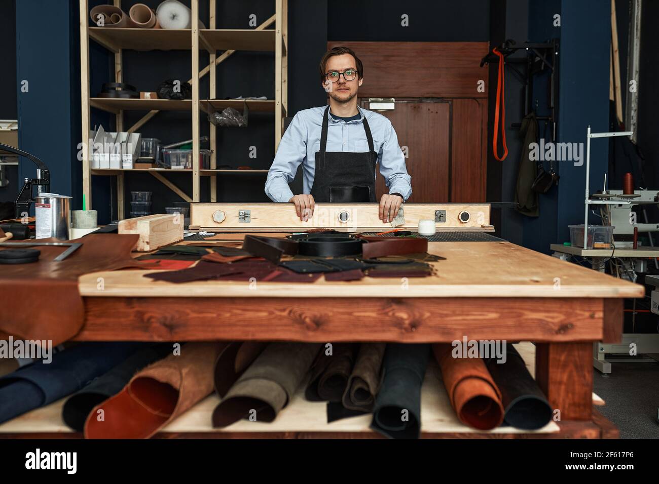 Skilled leather manufacture worker cutting some samples in workshop studio. Stock Photo