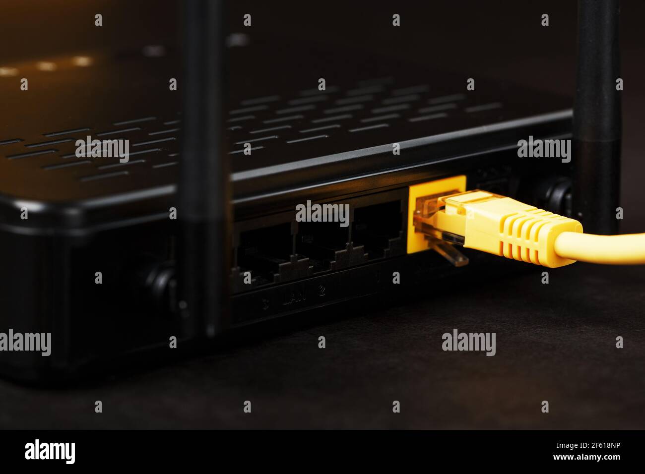 Wireless modem router with yellow cable and LAN port for connection on a  black background. wireless LAN technology with devices based on IEEE 802.11  s Stock Photo - Alamy