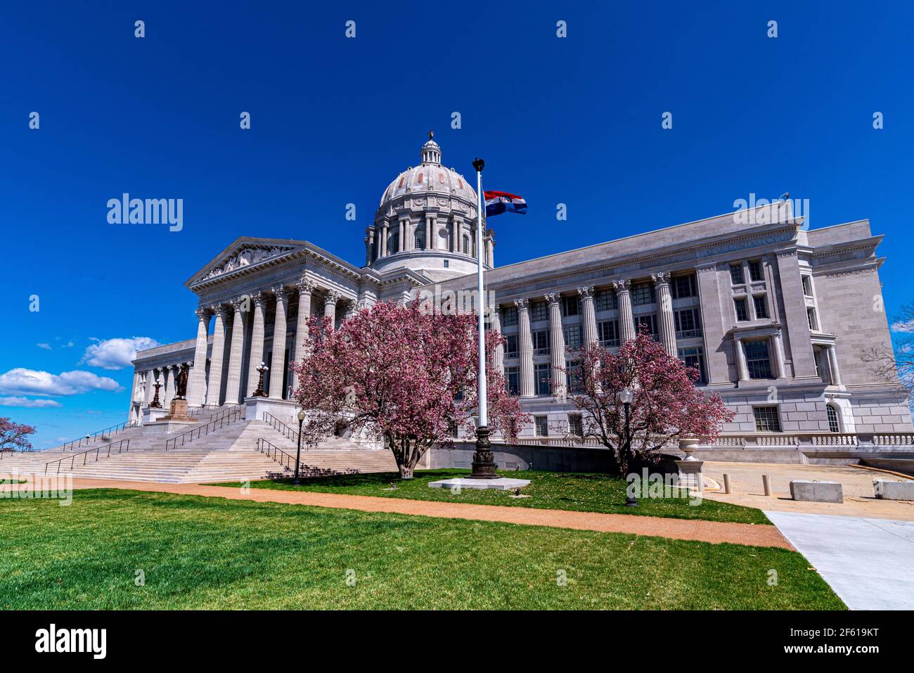 Missouri State Capitol with pink magnolia tree flowers in spring that houses General Assembly and executive branch of the government in Jefferson City Stock Photo