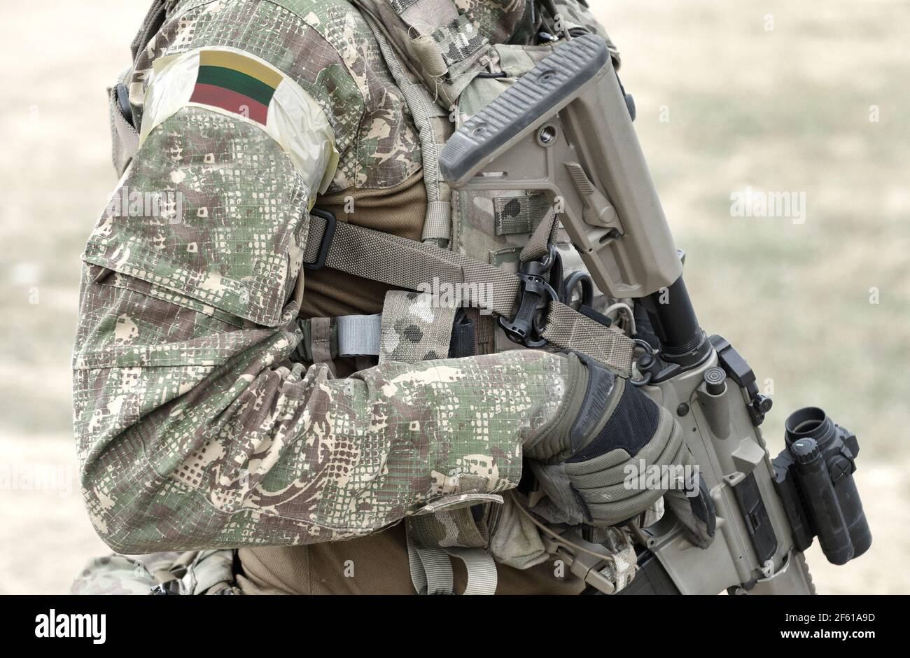 Soldier with assault rifle and flag of Lithuania on military uniform. Collage. Stock Photo