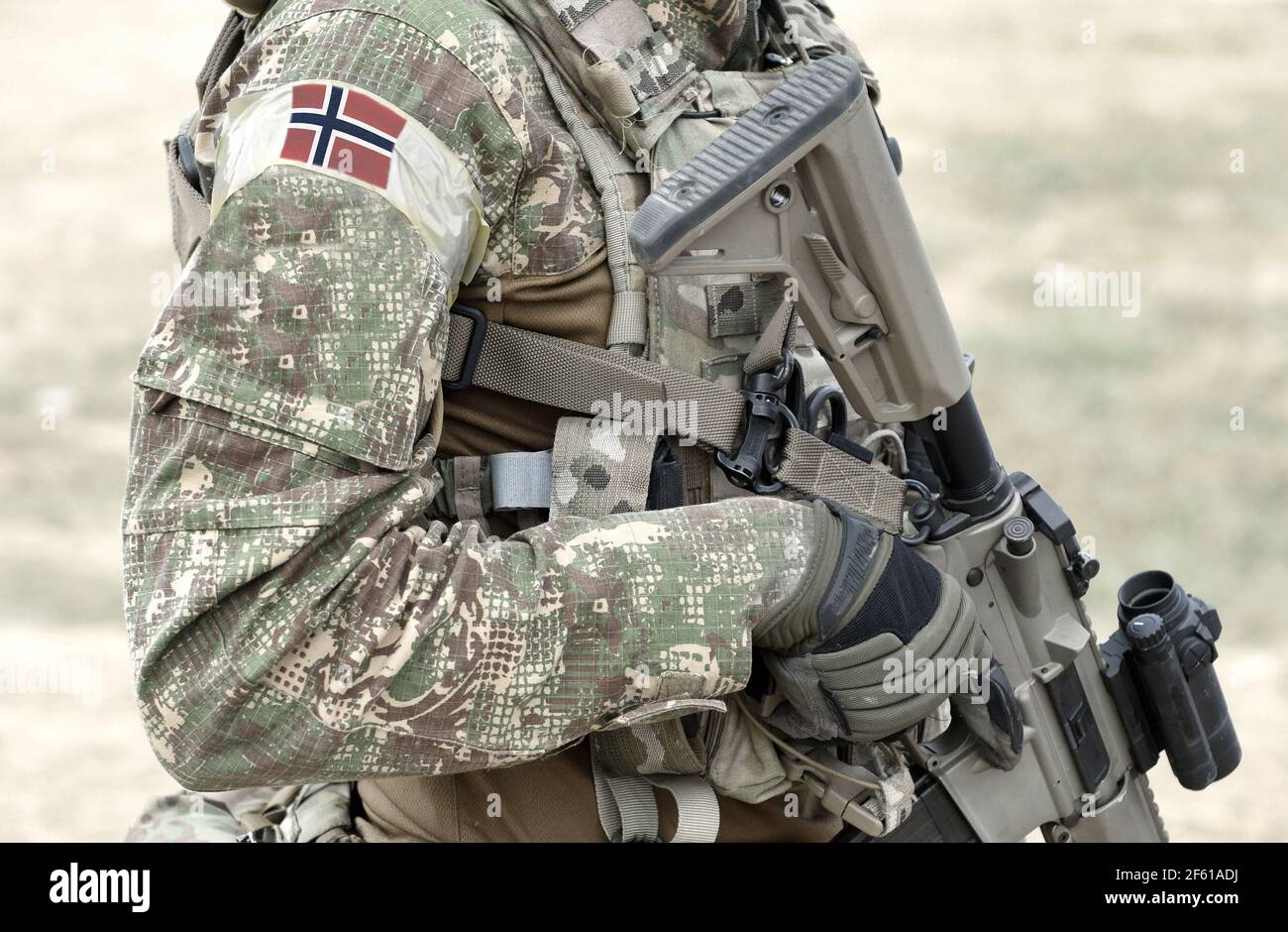 Soldier with assault rifle and flag of Norway on military uniform