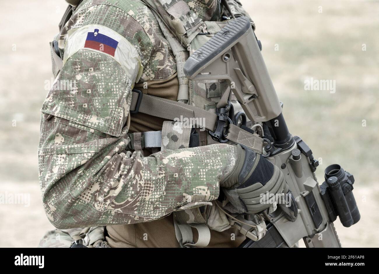 Soldier with assault rifle and flag of Slovenia on military uniform. Collage. Stock Photo