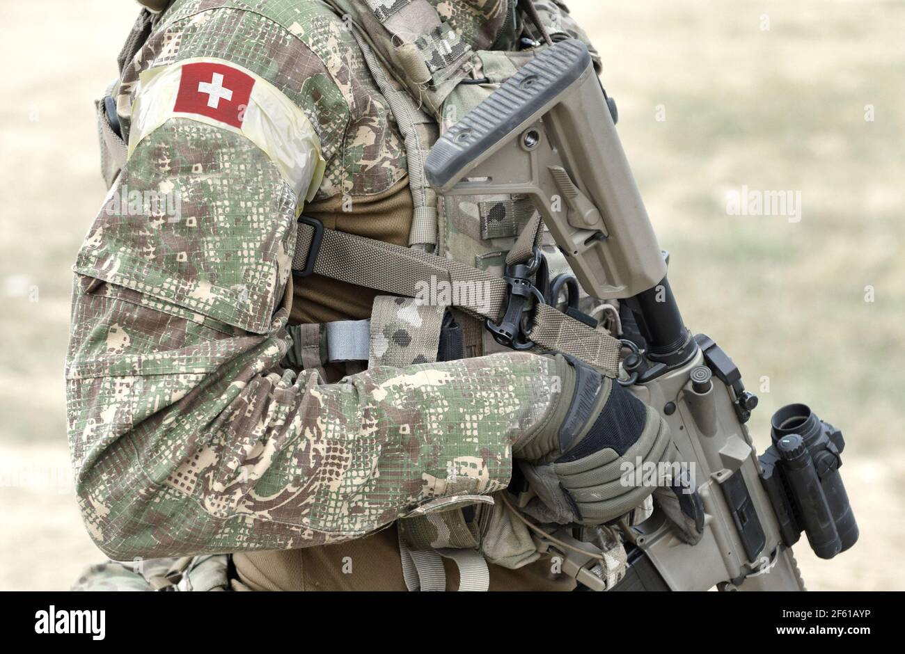 Soldier with assault rifle and flag of Switzerland on military uniform