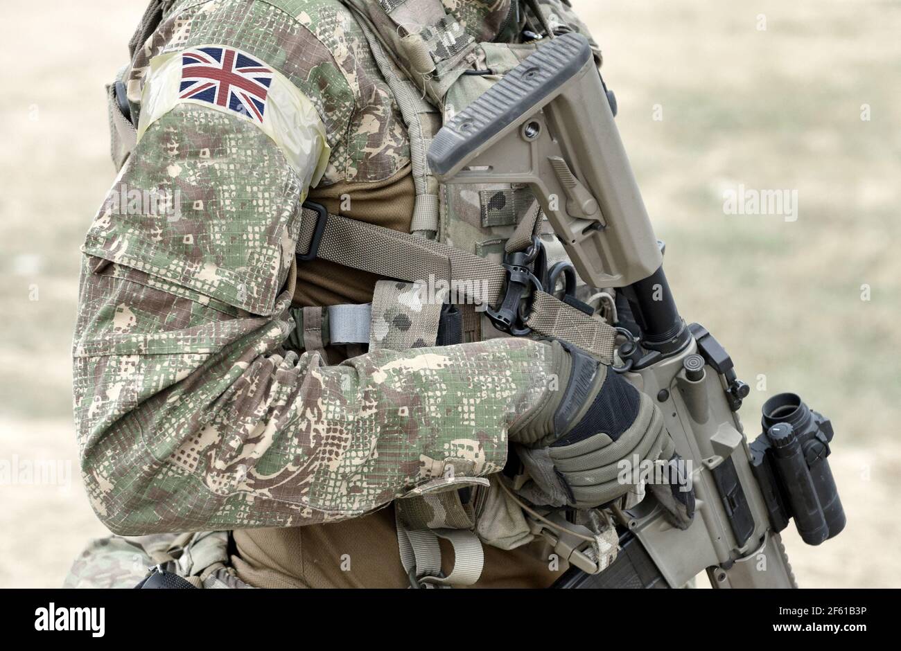 Soldier with assault rifle and flag of United Kingdom on military uniform. Collage. Stock Photo