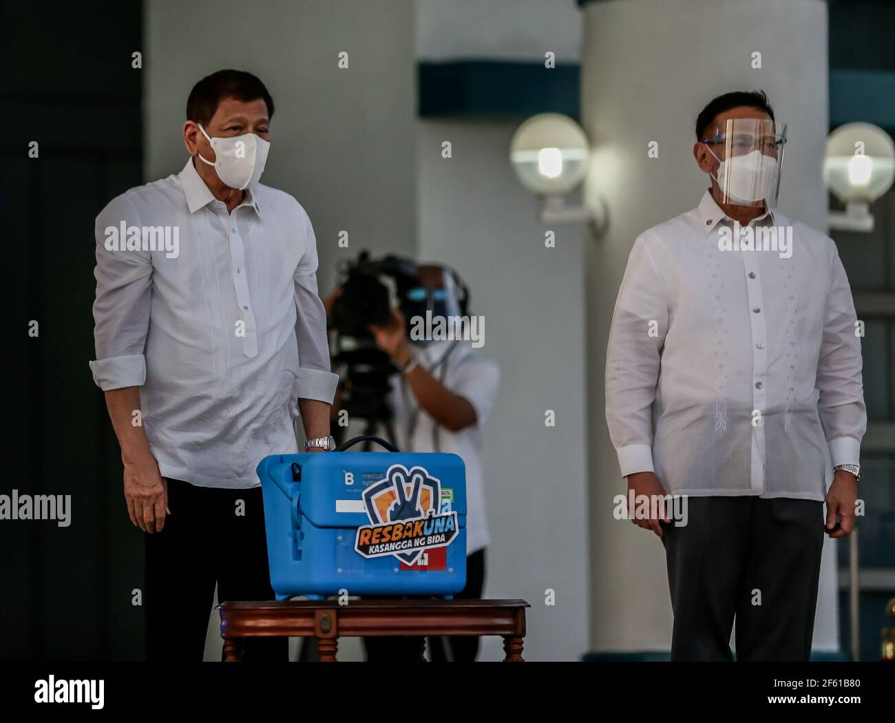 Manila, Philippines. 29th Mar, 2021. Philippine President Rodrigo Duterte (L) stands beside Health Secretary Francisco Duque as they present a case containing government-purchased Sinovac COVID-19 vaccines in Manila, the Philippines, on March 29, 2021. The Philippines on Monday received the first batch of the Sinovac COVID-19 vaccines its government has purchased from China. Credit: Rouelle Umali/Xinhua/Alamy Live News Stock Photo