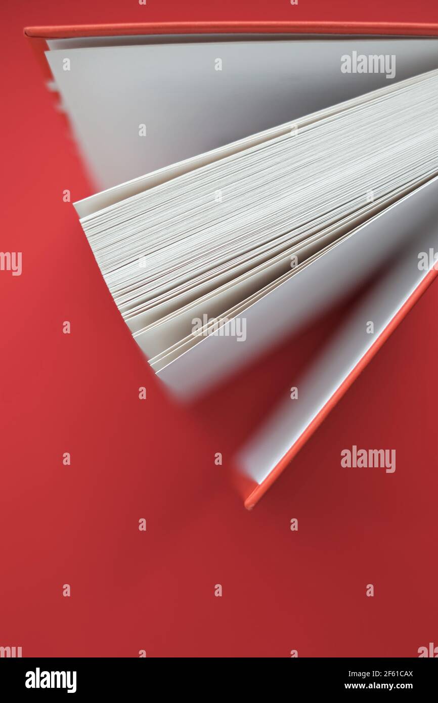 Reading books.Learning and knowledge concept. Book with a red cover on a red background.books close up. Book pages.  Stock Photo