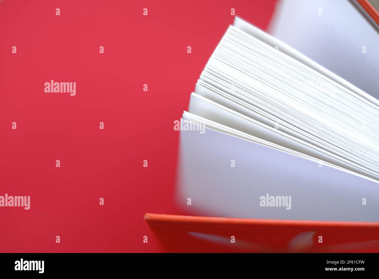 Reading books.Learning and knowledge concept. Book with a red cover on a red background.books close up. Book pages. top view, copy space Stock Photo