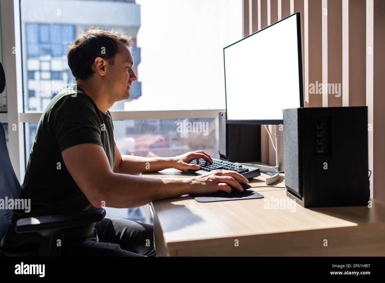 Man sitting at desk working from home on computer Stock Photo - Alamy